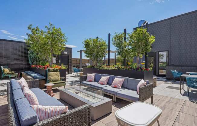 a rooftop patio with couches and tables and trees