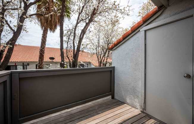 a balcony with a view of trees and a house