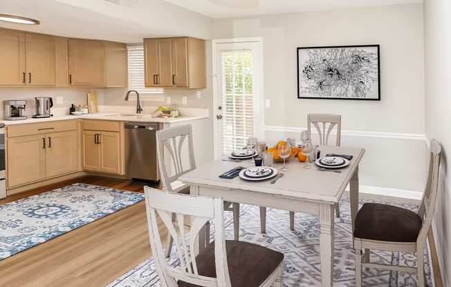 table in a dining area opening up to the kitchen