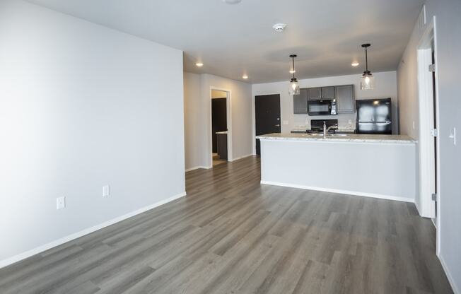 Modern open-concept kitchen and living area with black appliances.