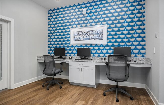 Room with a long desk with computer monitors and chairs