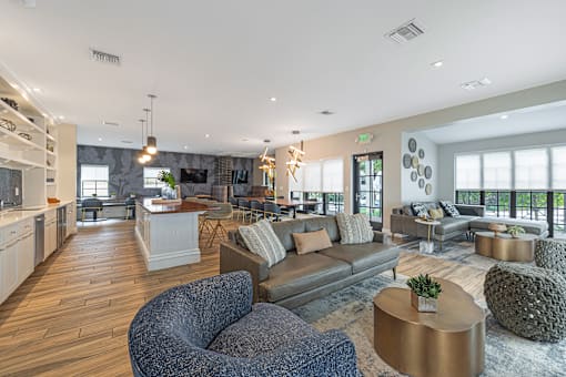 a living room with couches and chairs and a kitchen