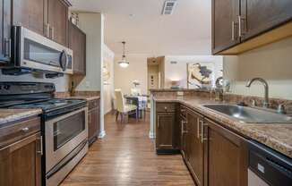 A kitchen with dark wood cabinets and a black stove top oven.