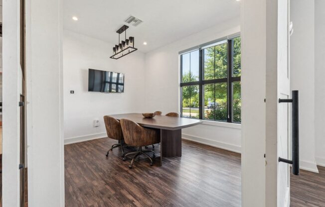 a conference room with a table and chairs and a large window