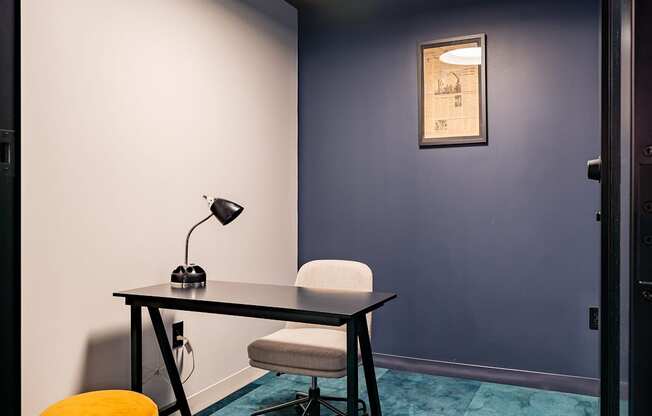a room with a desk and a chair and a lamp