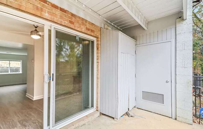 the entrance to a home with a white door and a sliding glass door