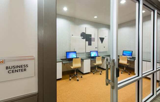 A business center with computers and chairs.