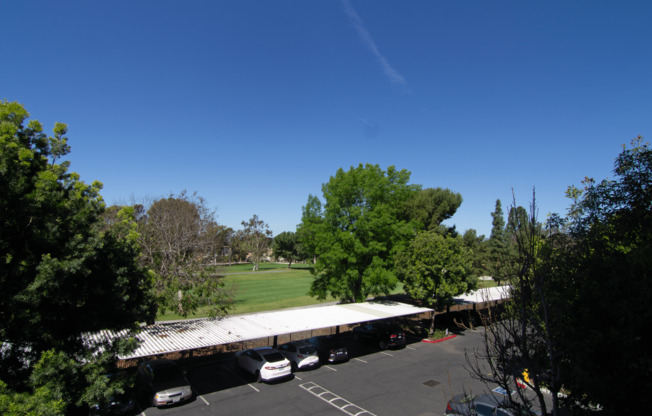 A parking lot with cars and a large building in the background.