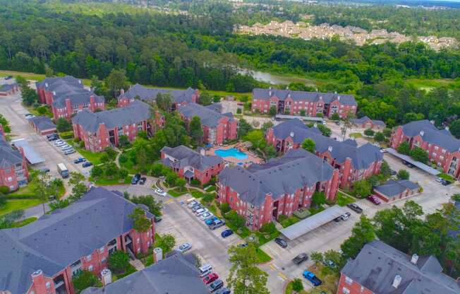 arial view of a large brick housing complex with a blue pool in the middle of the
