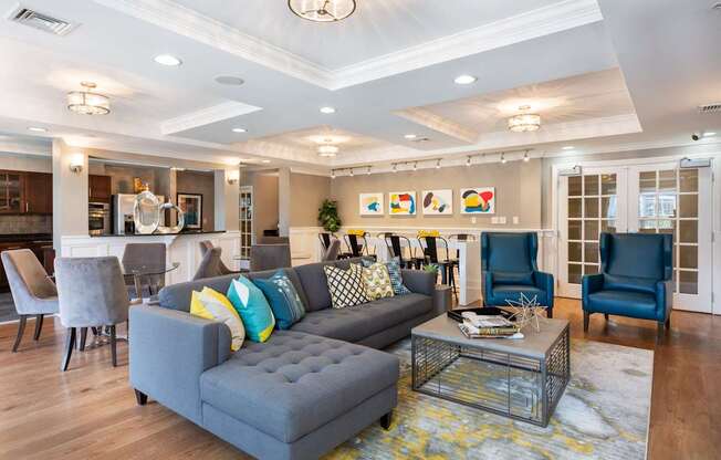 Resident Lounge with Sectional Sofa and Dual Chair Seating, Full Kitchen and Family Style Table Seating and Two Separate Tables with Four Chairs at Canton Woods apartments in MA