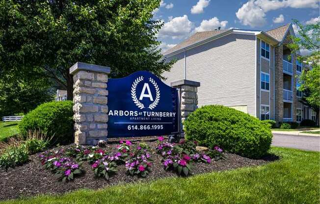 a sign in front of a building with flowers