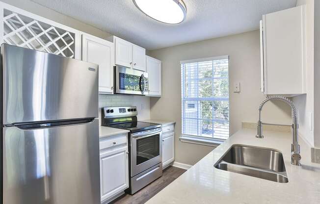 a kitchen with white cabinets and stainless steel appliances