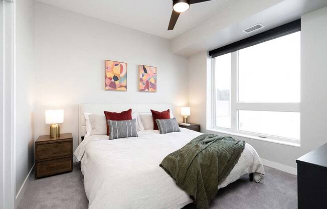 A bedroom with a bed, nightstands, and a ceiling fan.