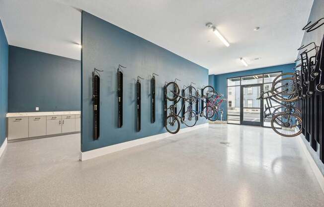 a large room with bikes hanging on a blue wall at The Quarry Luxury Apartment Homes, Fort Collins