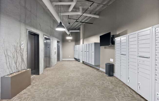 a row of lockers in a room with a hallway and a television