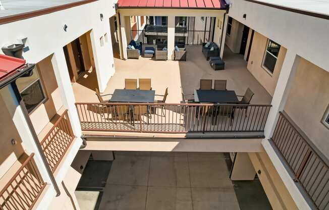 arial view of the balcony of a building with tables and chairs