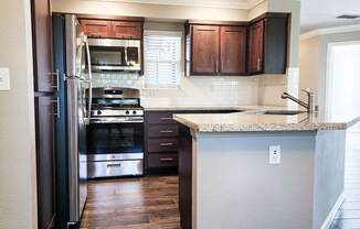 kitchen with wood-like floors and stainless appliances