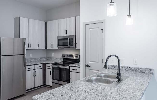 A kitchen with a granite countertop and stainless steel appliances.