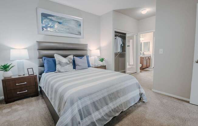 A bedroom with a large bed and a painting on the wall.