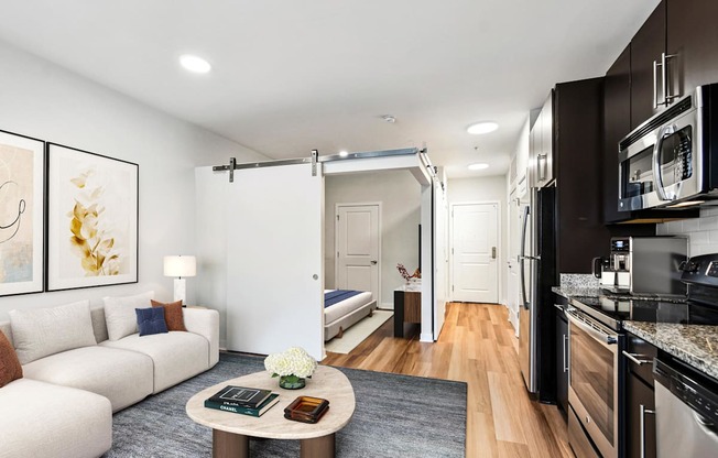 A modern kitchen with a breakfast table and a white sofa.