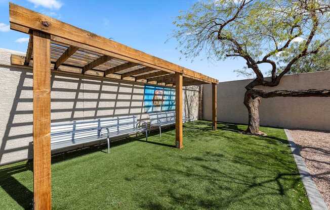 A wooden pergola with a bench underneath it.