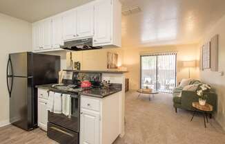 A kitchen with black appliances and white cabinets at Zinfandel Village Apartments, California, 95670