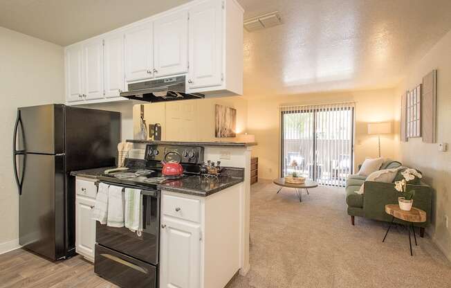 A kitchen with black appliances and white cabinets at Zinfandel Village Apartments, California, 95670