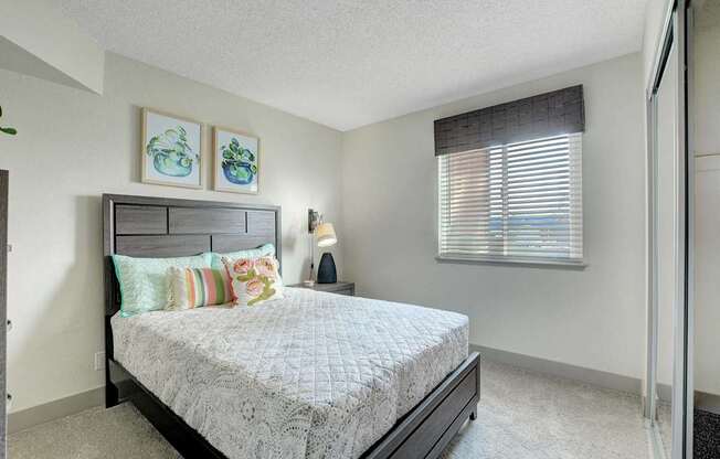 A bedroom with a bed, pillows, and a nightstand.