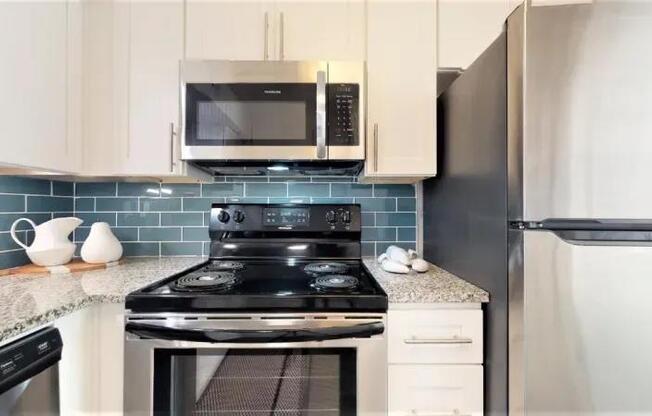 A kitchen with a black stove top oven and a black refrigerator.
