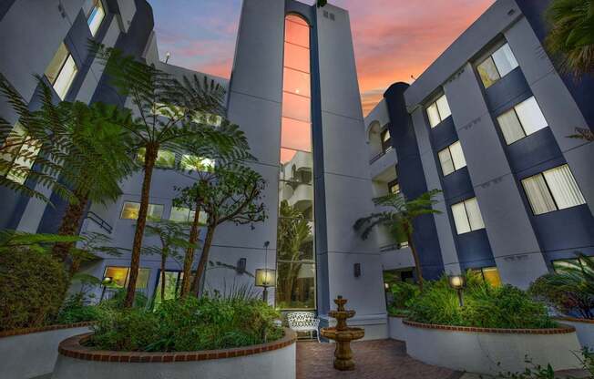 A modern building with a courtyard and a fountain at dusk. at Midvale Court, Los Angeles