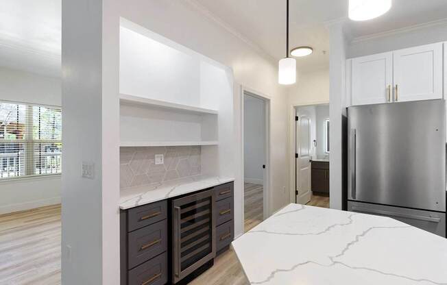 A kitchen with a marble counter top and stainless steel appliances.