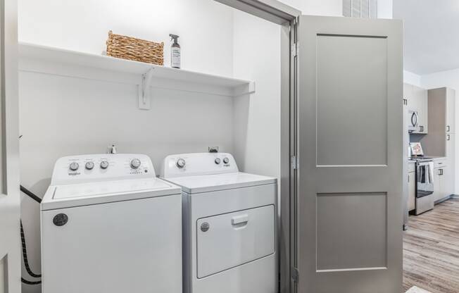 a small laundry room with a washer and dryer and a shelf above the washer at Prism at Diamond Ridge, Pennsylvania, 15108