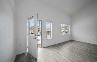 a bedroom with hardwood floors and white walls