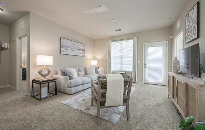 A living room with a couch, a chair, and a television.