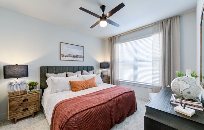 a bedroom with a bed and a ceiling fan