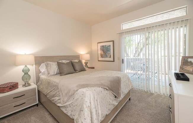 A bedroom with a large bed and a window with blinds at Autumn Oaks Apartments, Roseville, CA, 95678