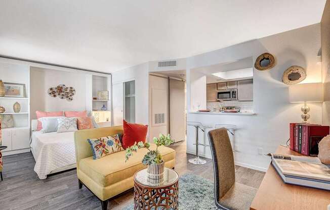 A living room with a yellow couch and a coffee table.