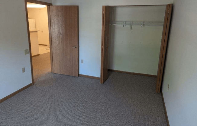 an empty room with a closet and an open door