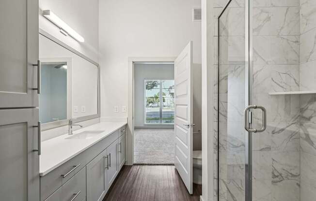 A bathroom with a marble wall and a window.