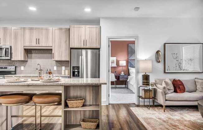 A modern kitchen with a bar area and a living room.
