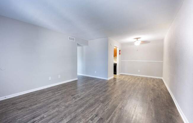 A room with wooden flooring and white walls.