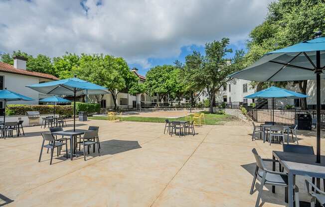 a patio with tables and chairs and umbrellas