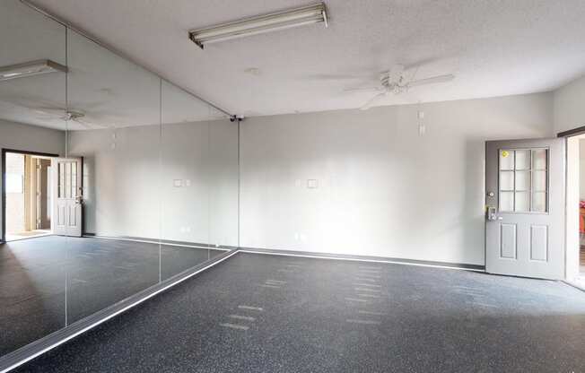 an empty room with mirrored walls and a door