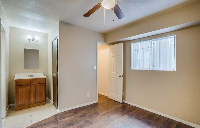 A room with a ceiling fan and a wooden cabinet.