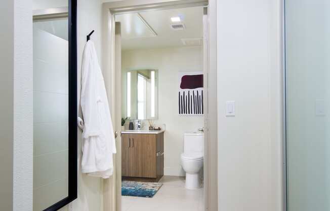 a white bathroom with a large mirror and a white toilet