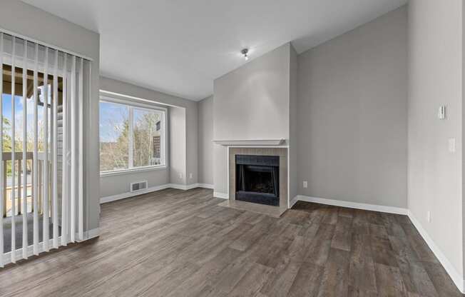 an empty living room with a fireplace and a window