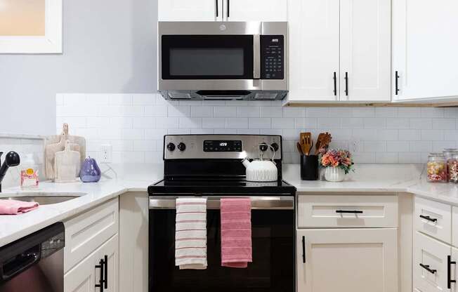 A modern kitchen with a stove top oven and microwave above it.