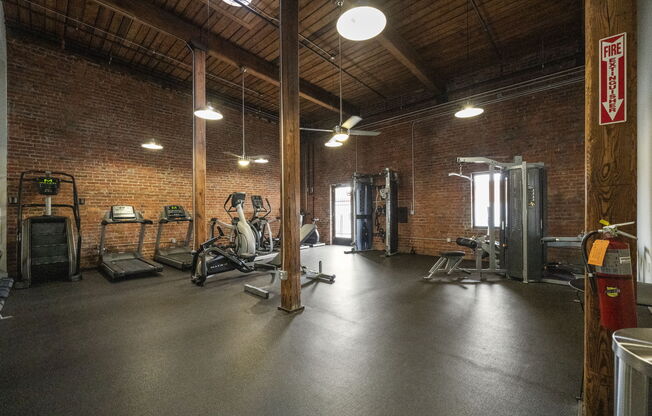 a gym with brick walls and a wooden ceiling
