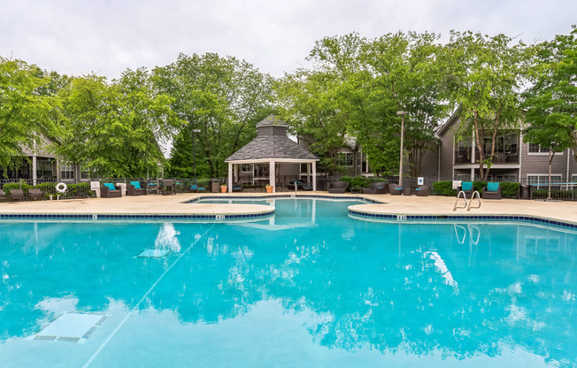 a large swimming pool with a gazebo and a resort style hotel pool