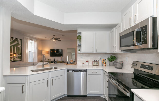 a kitchen with white cabinets and stainless steel appliances at Deerfield Village, Georgia